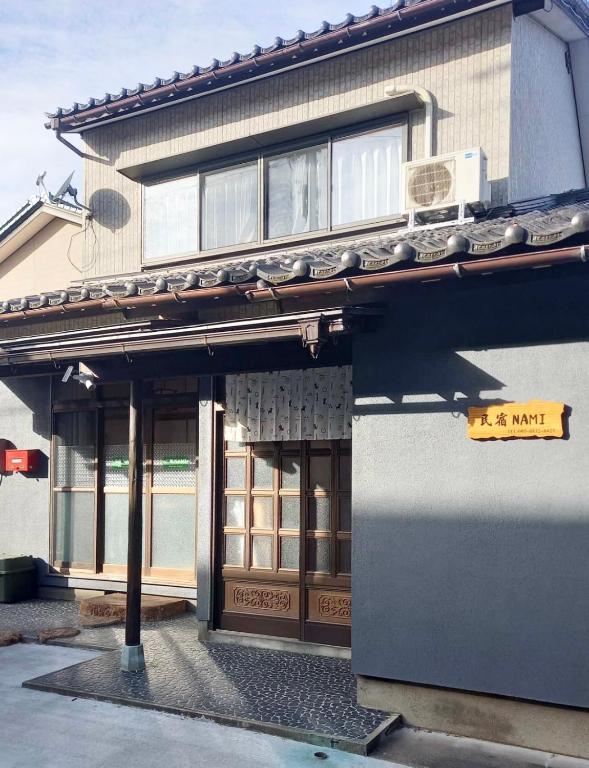 a building with a sign on the side of it at 民宿NaMi in Awara