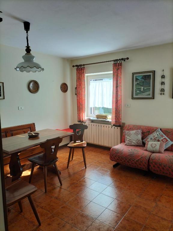 a living room with a table and a couch at Appartamento l'angelo in Predazzo