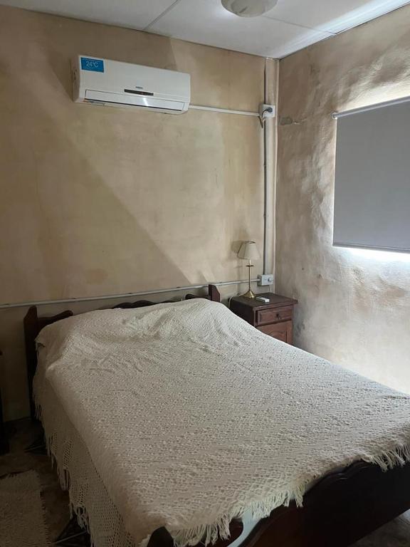a bedroom with a white bed and a window at Quinta Atardeceres in Aldea Brasilera