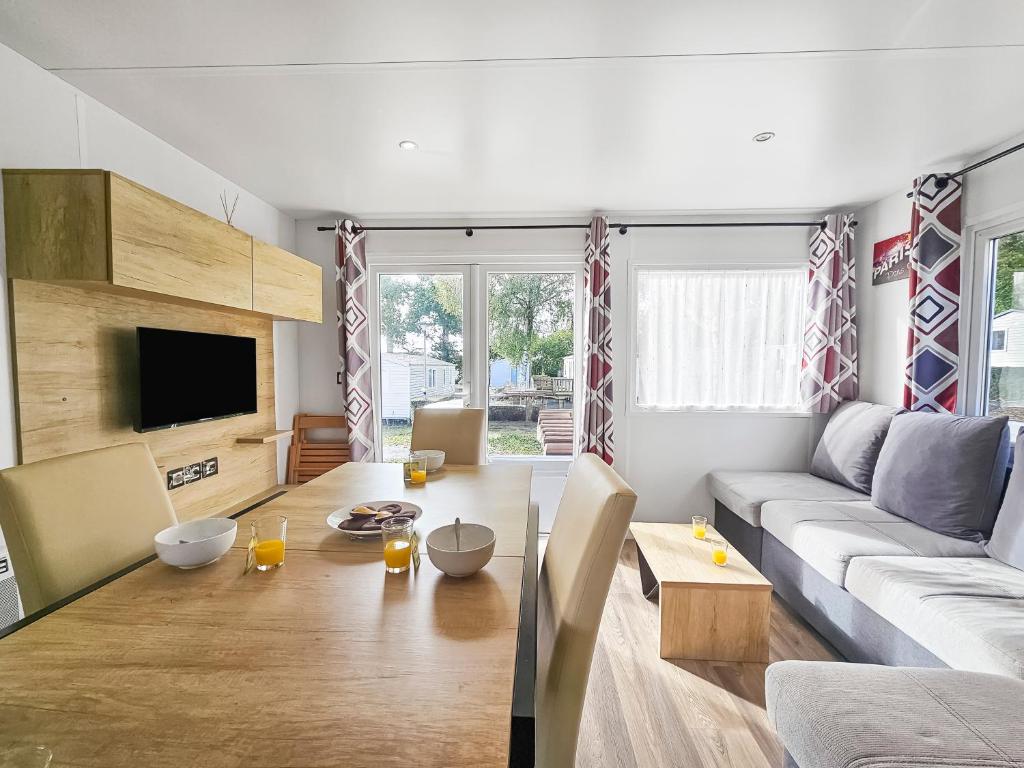 a living room with a couch and a table at L'horizon du bonheur in Litteau