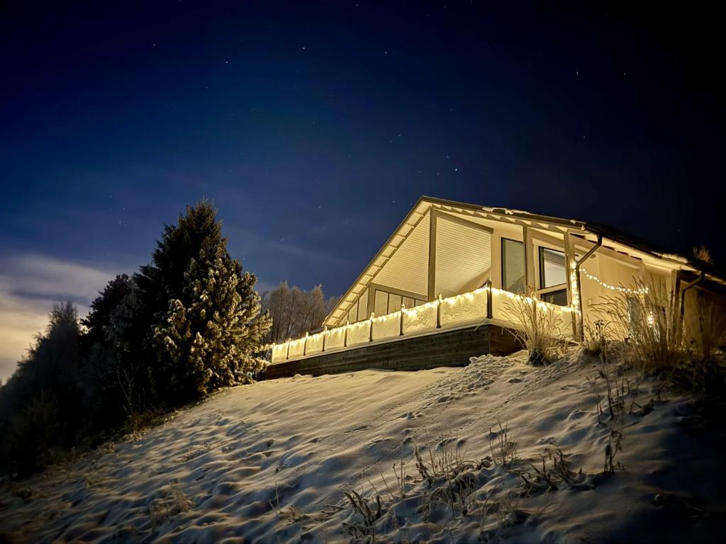 a house in the snow at night at Aurora Arctic Riverside Villa in Rovaniemi