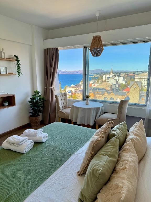a bedroom with a large bed with a large window at Studio vista al lago in San Carlos de Bariloche