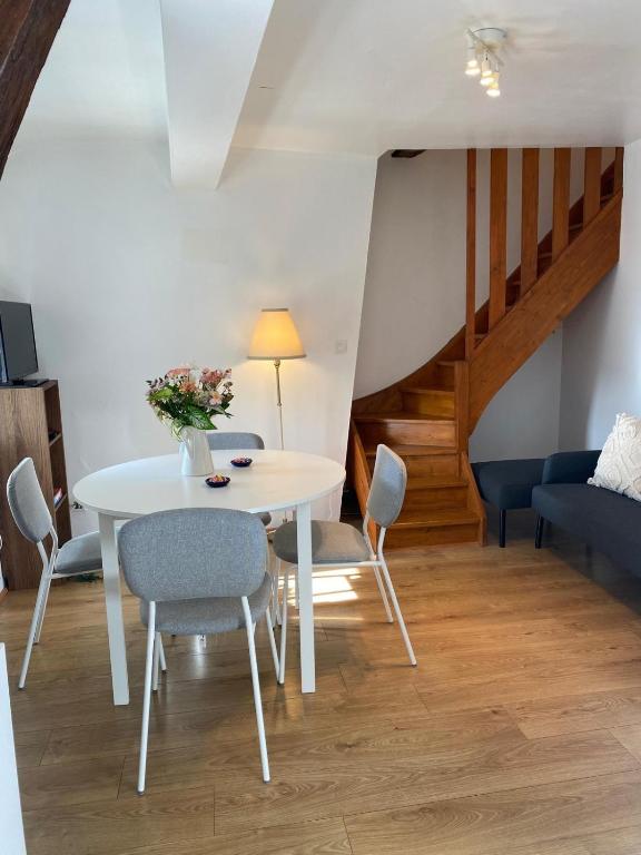een eetkamer met een witte tafel en stoelen bij Le Duplex Cosy in Orléans