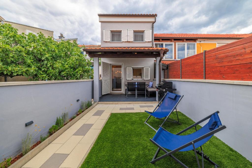 a yard with two chairs and a house at Kuca za Odmor Ena in Jadranovo