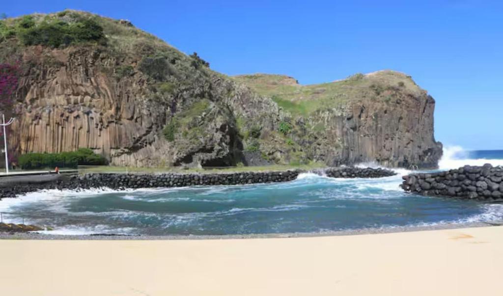 un fiume con una montagna sullo sfondo di House Villa Butterfly a São Roque do Faial