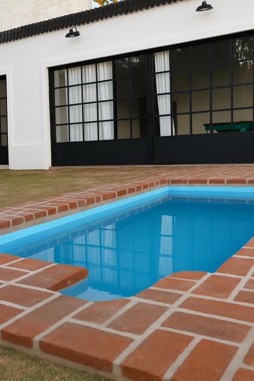 a swimming pool in front of a house at Rincon de Tucuns in San José del Rincón