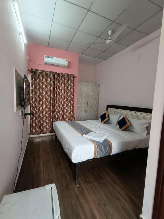a bedroom with a large bed and a tv at White Rabbit Rooms in Bangalore