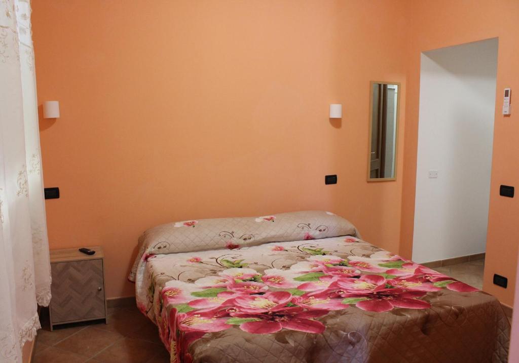 a bedroom with a bed with flowers on it at Agrimar 2 in Rignano Flaminio