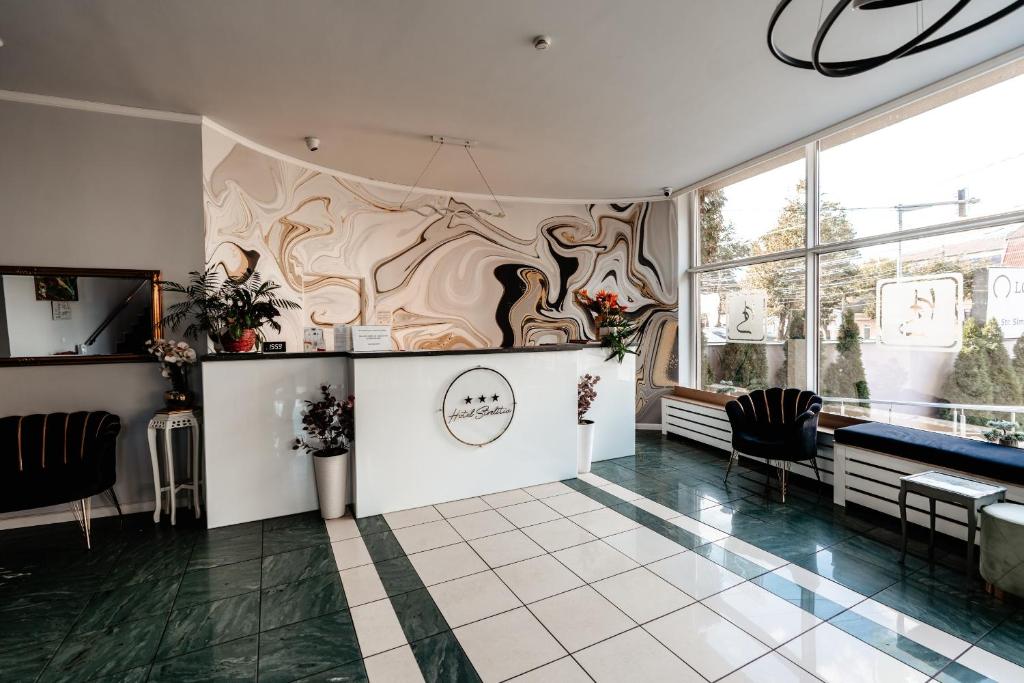 un salon avec un mur orné d'un tableau dans l'établissement Hotel Strelitia, à Timişoara