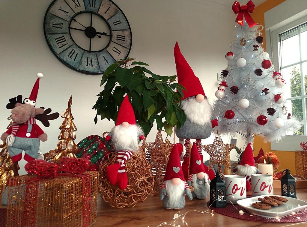 Eine Gruppe von Weihnachtsdekorationen auf einem Tisch mit einer Uhr in der Unterkunft Casa Quercus Galicia a 17 minutos de Compostela! in A Estrada