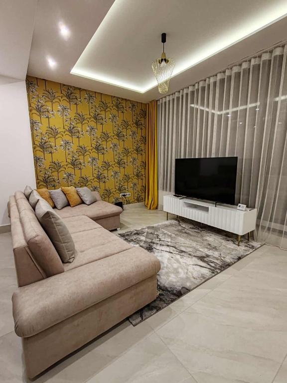 a living room with a couch and a flat screen tv at C-Home in Pécs