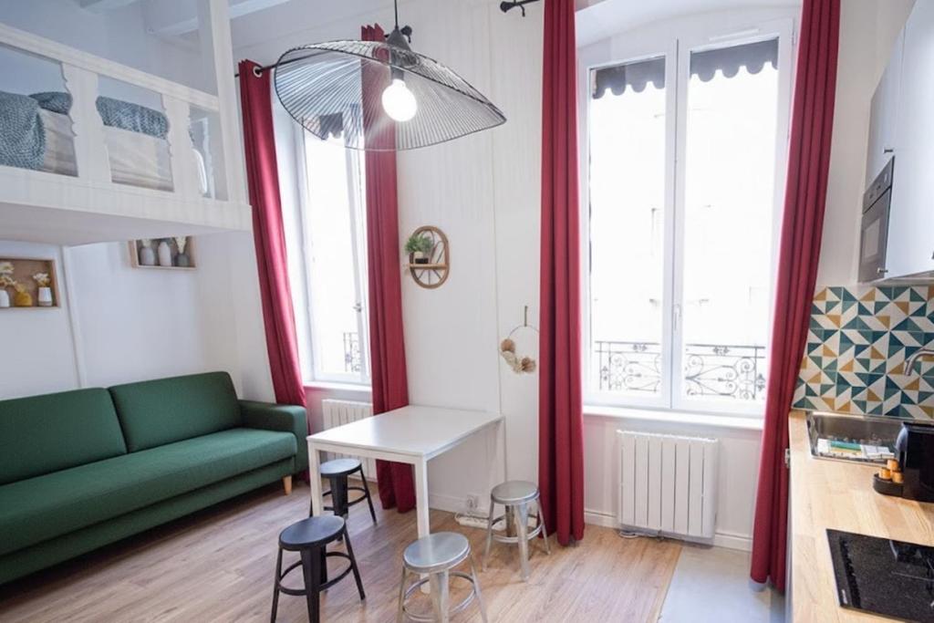 维勒班Le Petit Dedieu" Appartement cosy rénové pour 4 personnes Proche de Ch的客厅里有一张绿色的沙发和一张桌子