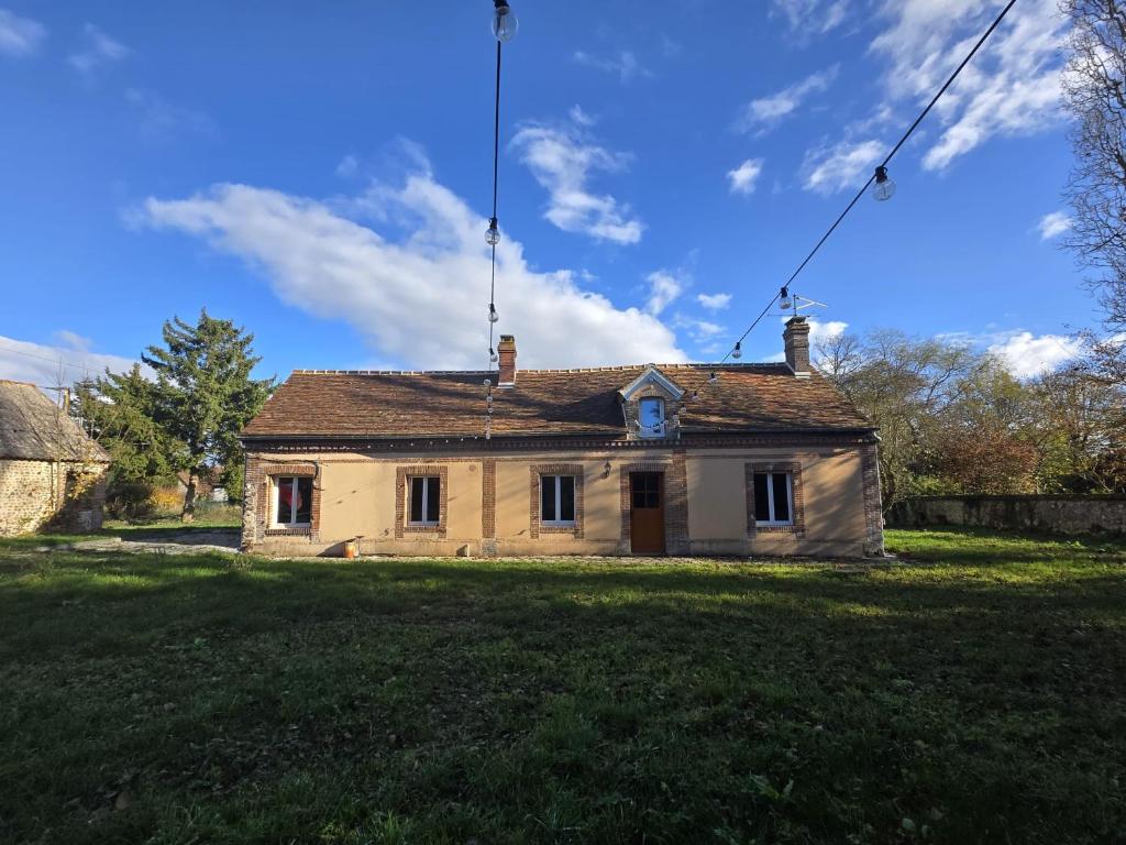 an old house on a grassy field in front at Longère d architecte calme et charme rural in Armentières-sur-Avre