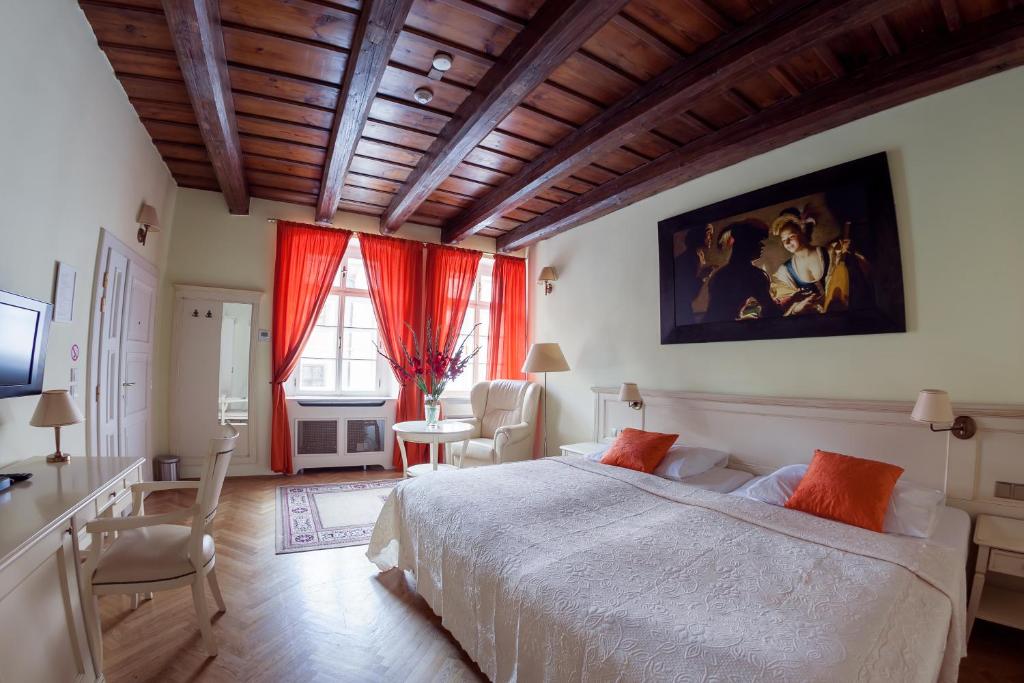 - une chambre avec un grand lit, une table et des chaises dans l'établissement Tyn Yard Residence, à Prague