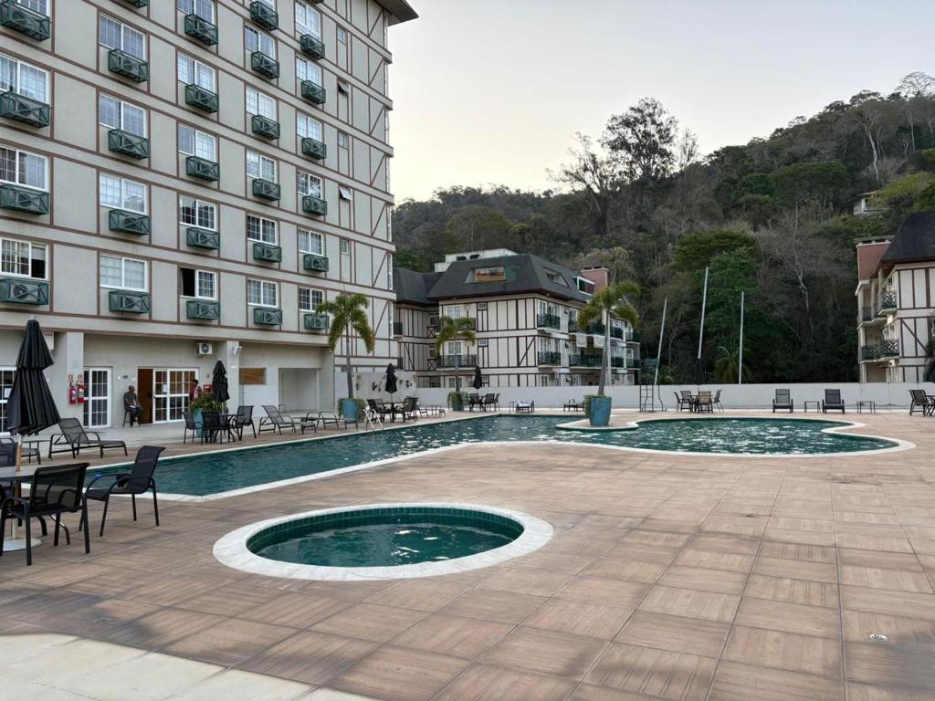 ein Hotel mit einem Swimmingpool vor einem Gebäude in der Unterkunft Studio aconchegante, com lazer completo na serra in Araras Petropolis
