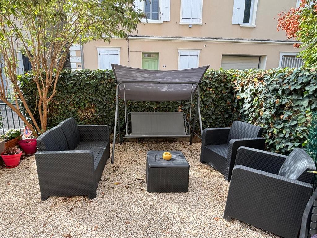 ニヨンにあるGîte cosy avec jardinのパティオ(椅子3脚、テーブル、グリル付)