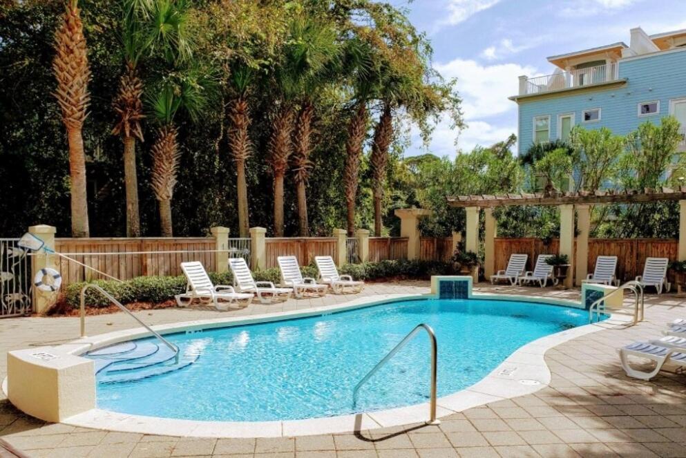 a large swimming pool with chairs and a house at Coastal Dunes Escape in Santa Rosa Beach