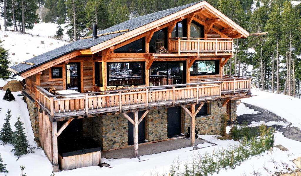 una baita di tronchi con un ponte avvolgente nella neve di Chalet « Le 1712 » direct pistes a Les Angles