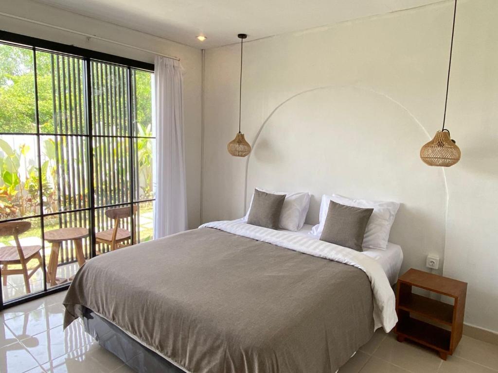 ein Schlafzimmer mit einem großen Bett und einem großen Fenster in der Unterkunft Yuli Homestay in Uluwatu