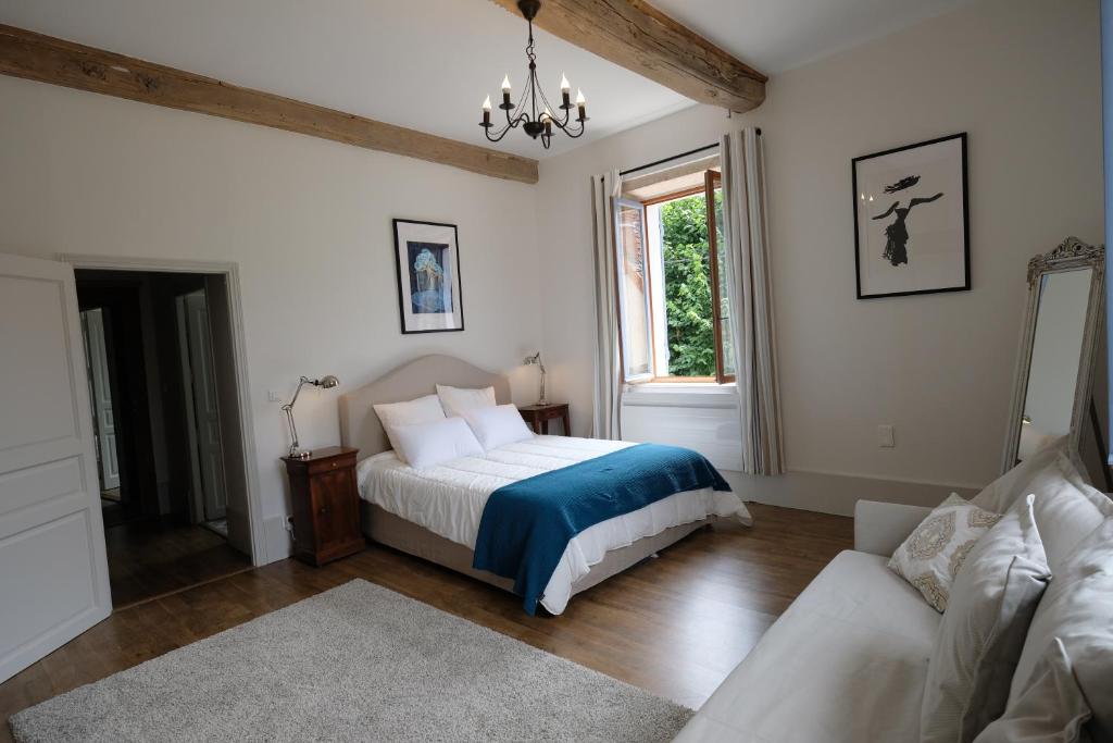 a bedroom with a bed and a couch and a window at Hippolyte House in Beaune