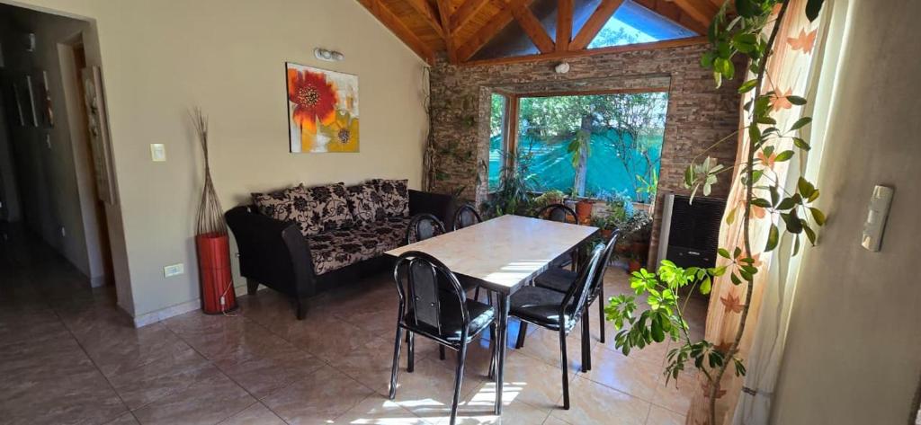 ein Wohnzimmer mit Tisch und Stühlen und einer Couch in der Unterkunft Valkara Patagonia in Las Golondrinas