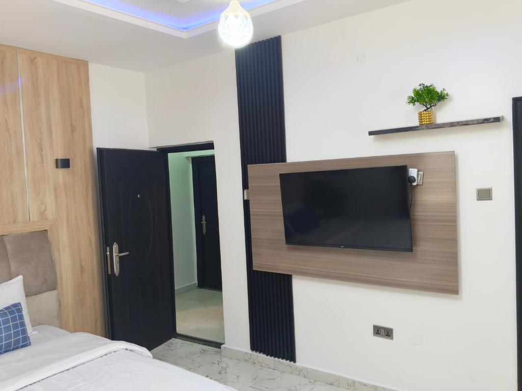ein Schlafzimmer mit einem Flachbildfernseher an der Wand in der Unterkunft Brandison Apartments in Port Harcourt