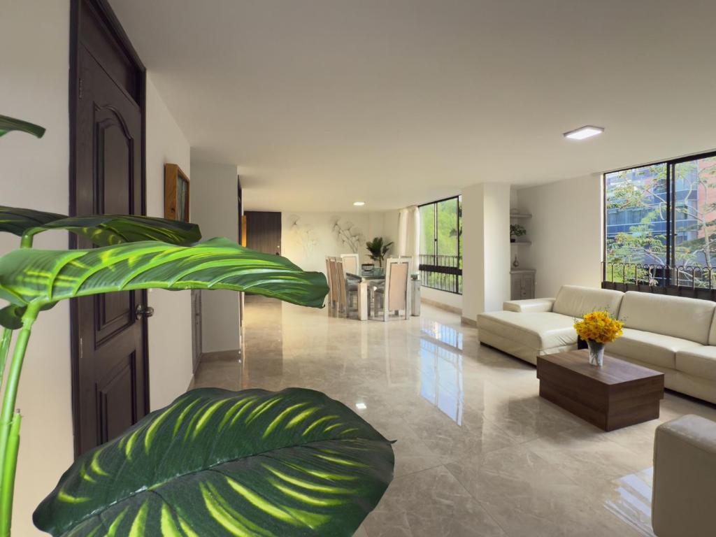 a large living room with a couch and a plant at 4br 232 M Apartment In El Poblado, El Tesoro in Medellín