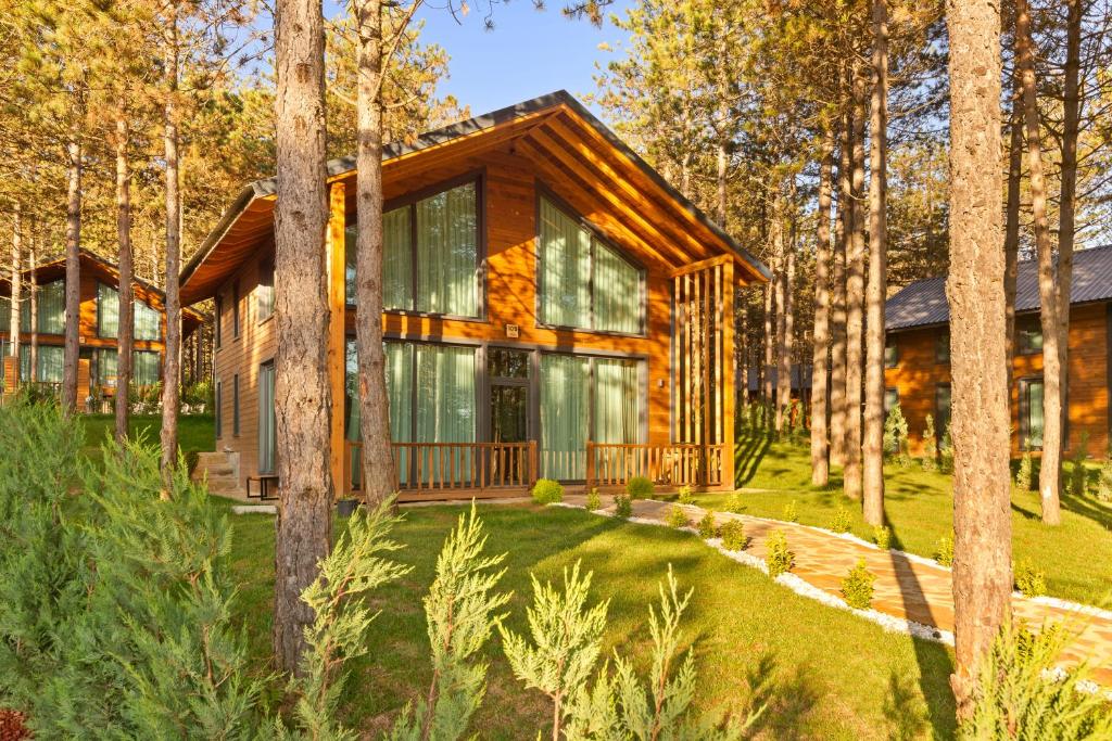 a log cabin in the woods with trees at Harmony Green Village Resort in Mahmudiye