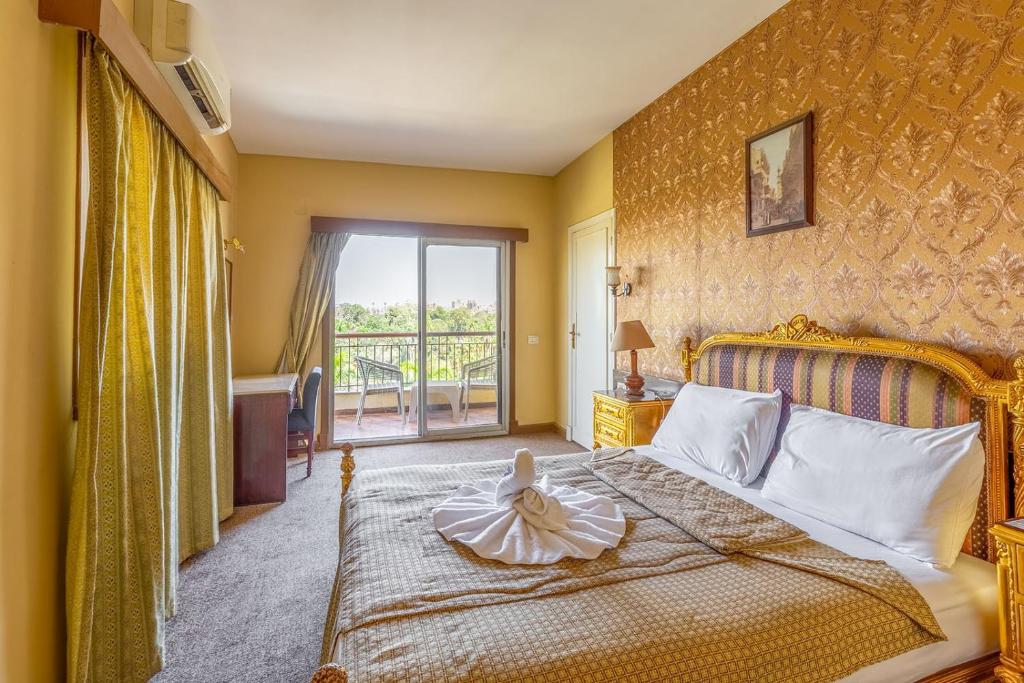 a bedroom with a large bed and a balcony at St George Hotel Cairo in Cairo