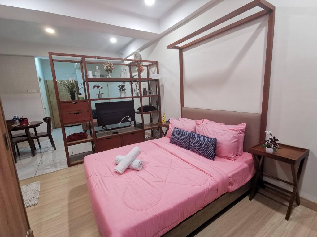 ein Schlafzimmer mit einem rosa Bett mit einer rosa Decke in der Unterkunft Timurbay Residence RY in Kampung Sungai Karang