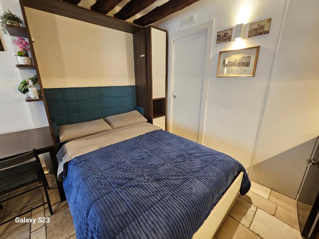 a bedroom with a bed with a blue comforter at Le Antiche Travi in Bari
