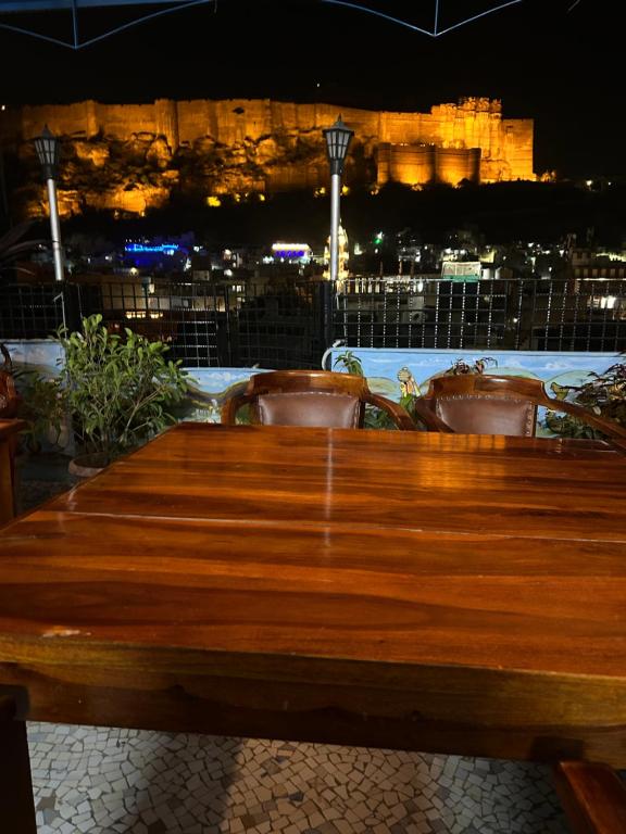 焦特布尔The Rajputana Haveli的一张木桌，窗外是夜幕下的城市景色