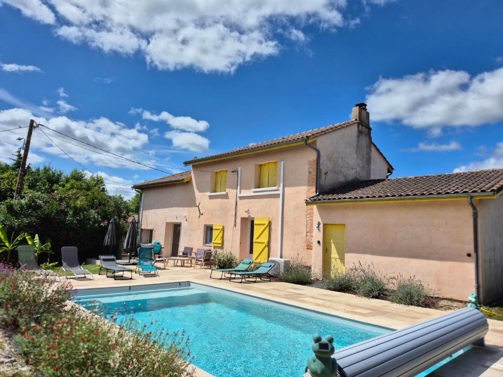 a house with a swimming pool in front of a house at Le Gîte du Pêcheur, en campagne pour 10 personnes, Piscine privée et jardin in Damazan