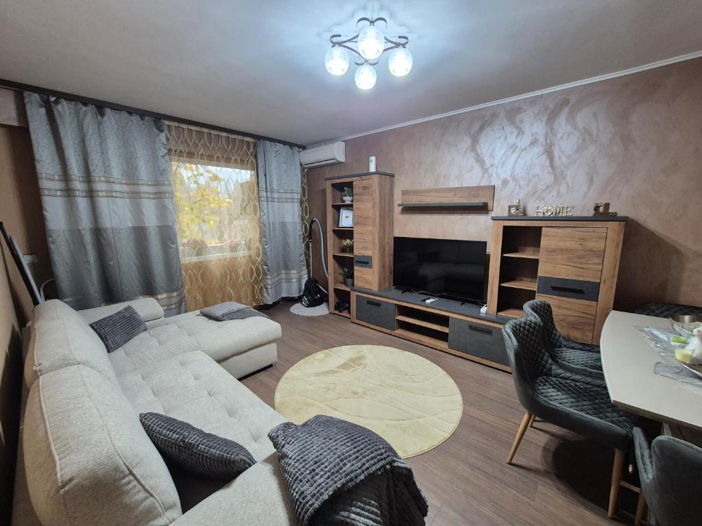a living room with a couch and a tv at Апартамент Михаел in Vidin