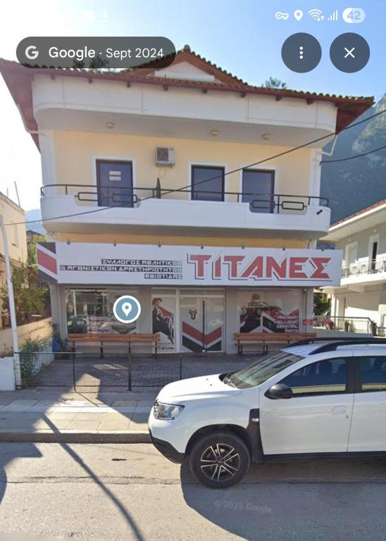 a white car parked in front of a building at Lily's Apartment in Kamena Vourla