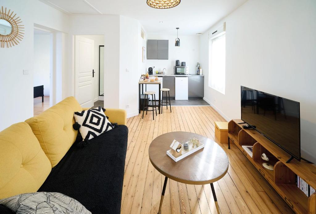 ルマンにあるLe Confort T2 tout équipé, proche Gare, Centre ville, Circuit des 24Hのソファとテーブルのあるリビングルーム