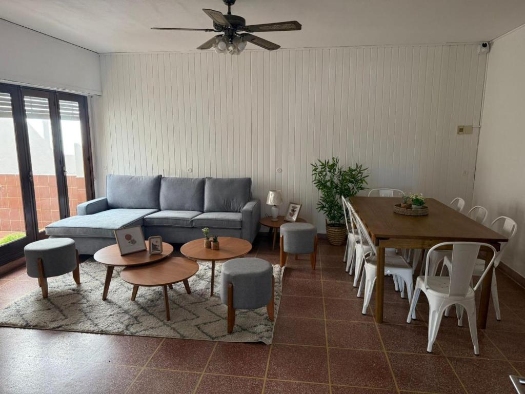 ein Wohnzimmer mit einer Couch sowie Tischen und Stühlen in der Unterkunft Cerrito hou in Paysandú