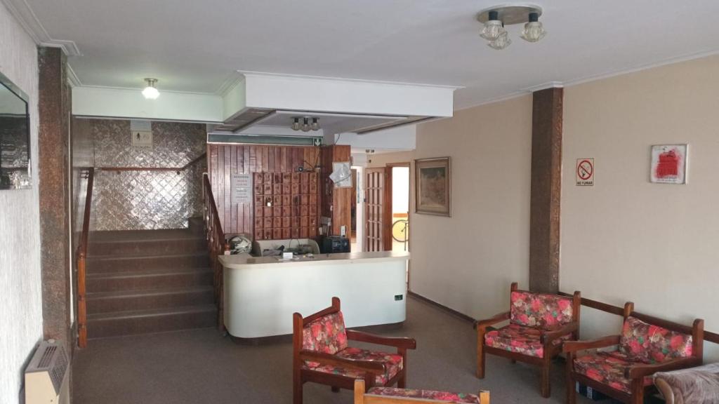 ein Wohnzimmer mit 2 Stühlen und einer Treppe in der Unterkunft Gran Hotel Avenida in Villa Gesell