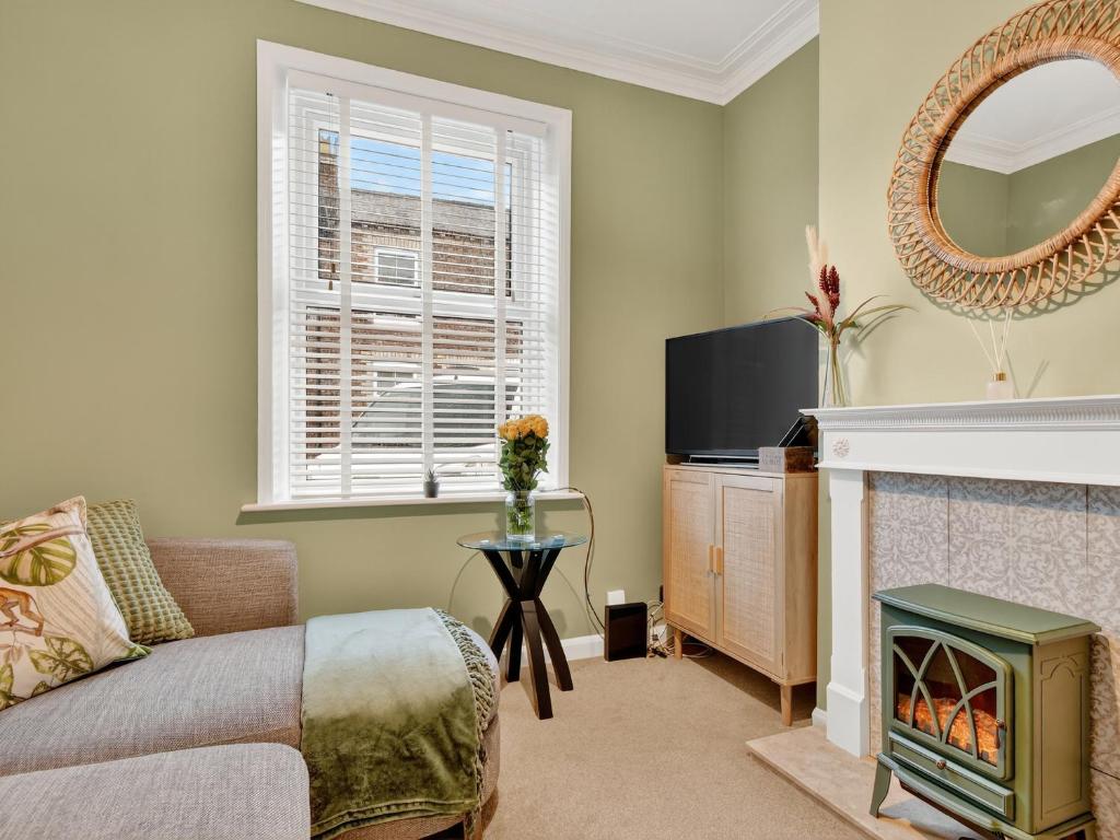 een woonkamer met een bank en een open haard bij Windsor Jay in York