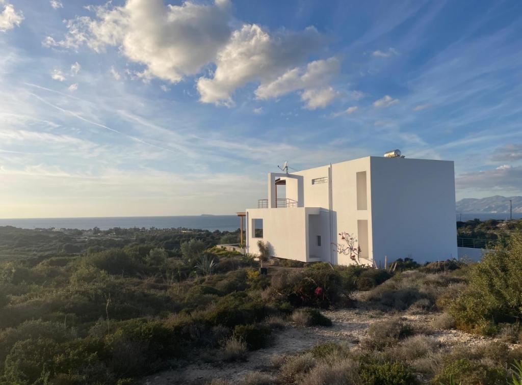 a white building on top of a hill at Villa Milan 2 Mastichari in Antimácheia
