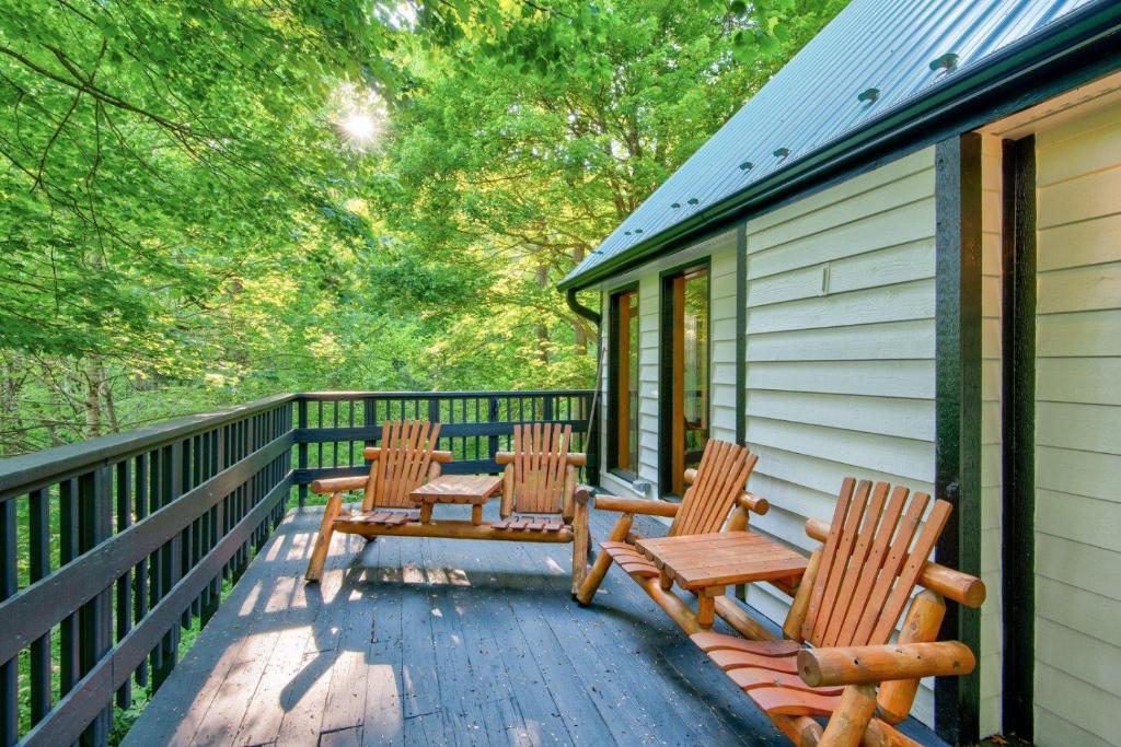 three wooden chairs sitting on a porch of a house at Paws A While in Blowing Rock