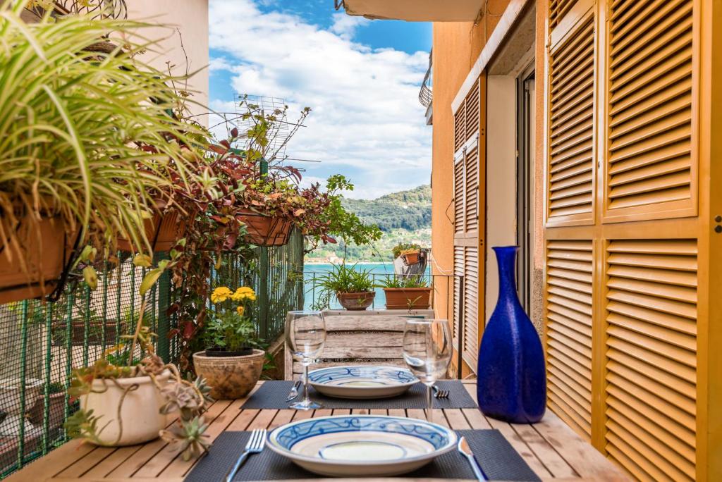 a table with plates and a blue vase on a patio at CameraPortivè Sea view & AC in Portovenere
