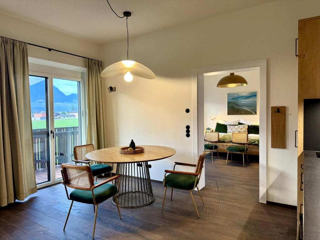 a living room with a table and chairs and a bedroom at Strumpfburg by Dollop Living in Kramsach