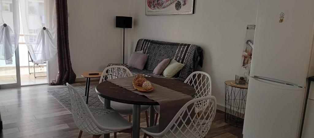 a kitchen with a table and chairs and a couch at Appartement tout confort in Salou