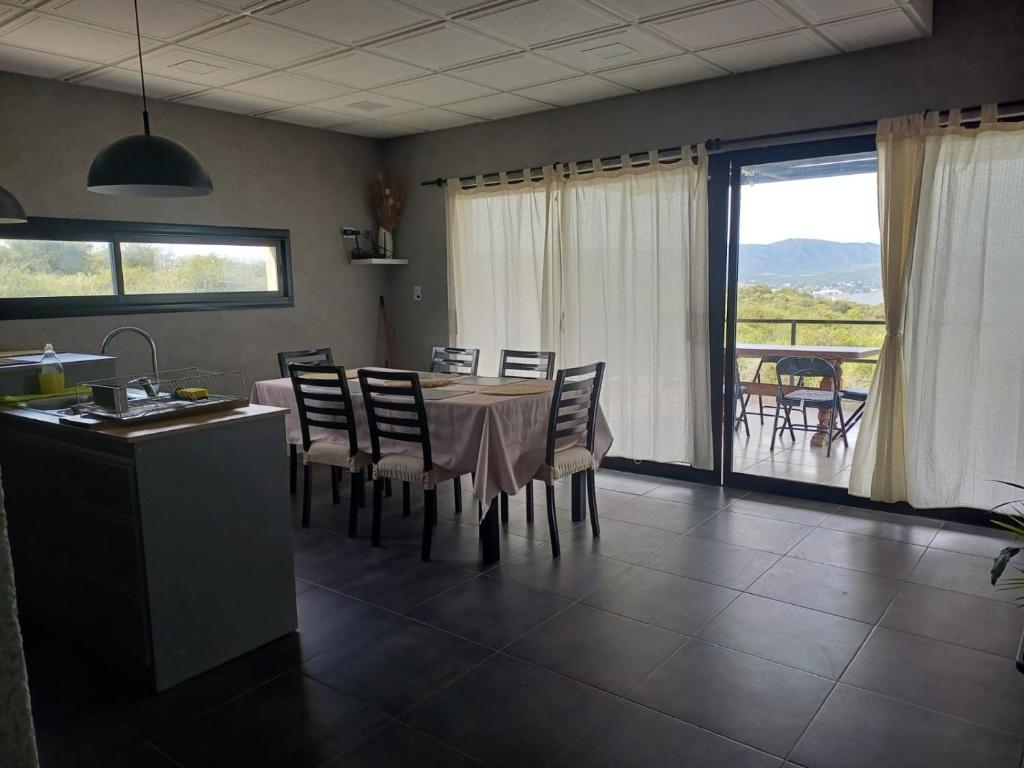 eine Küche und ein Esszimmer mit Tisch und Stühlen in der Unterkunft El Descanso in Villa Santa Cruz del Lago