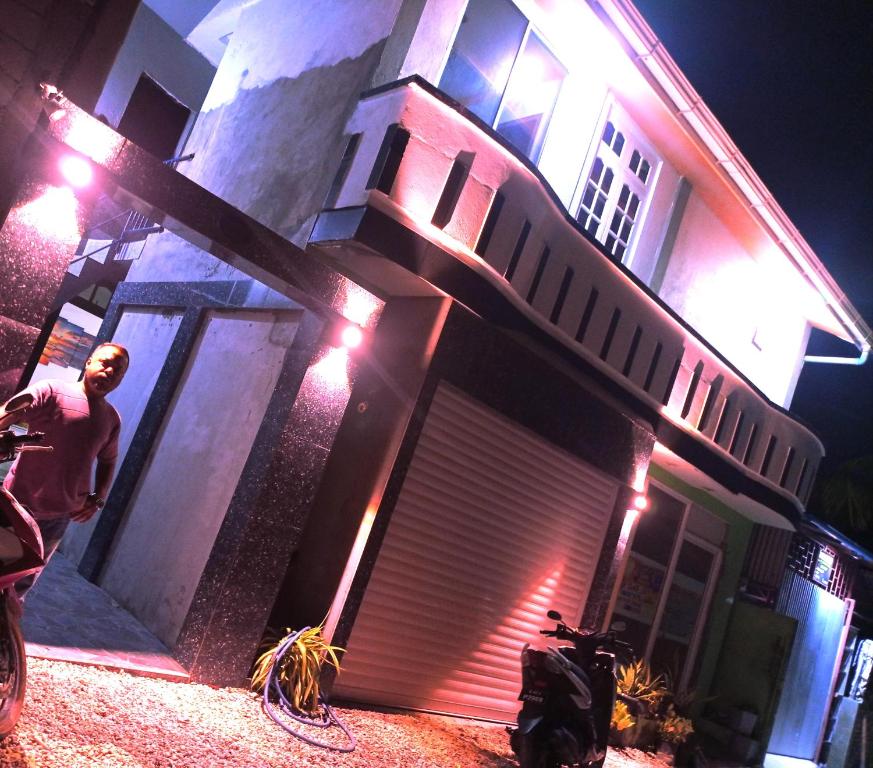 a man standing in front of a house at night at Save Sweet Home in Fuvahmulah