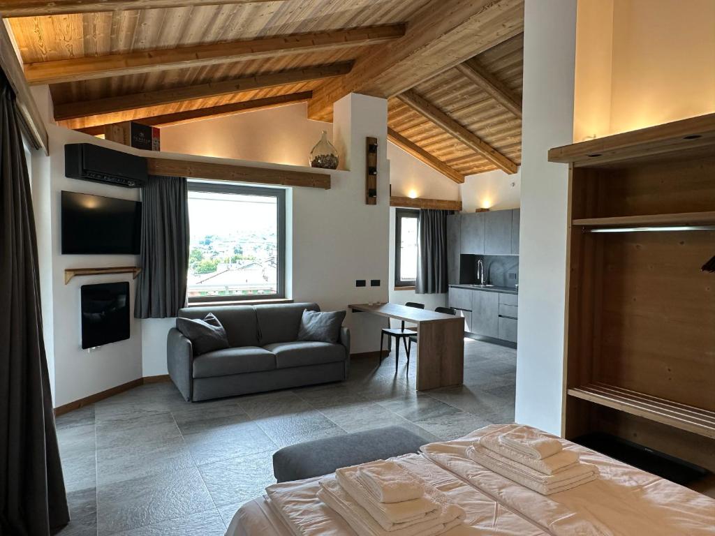 a bedroom with a bed and a living room with a couch at Valtellina SkyLine OVEST in Villa di Tirano