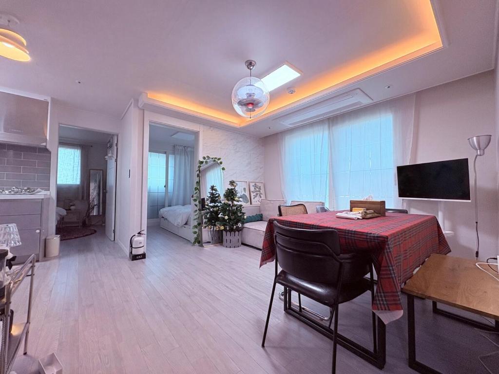 - un salon avec une table et une chambre avec un canapé dans l'établissement MAYs GO DUCK Newly built Family Stay KSPO IKEA Lotte World, à Séoul