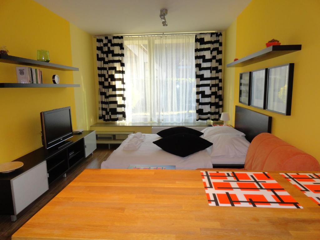 een slaapkamer met een bed en een televisie. bij Ski-Bike Čertovka in Harrachov