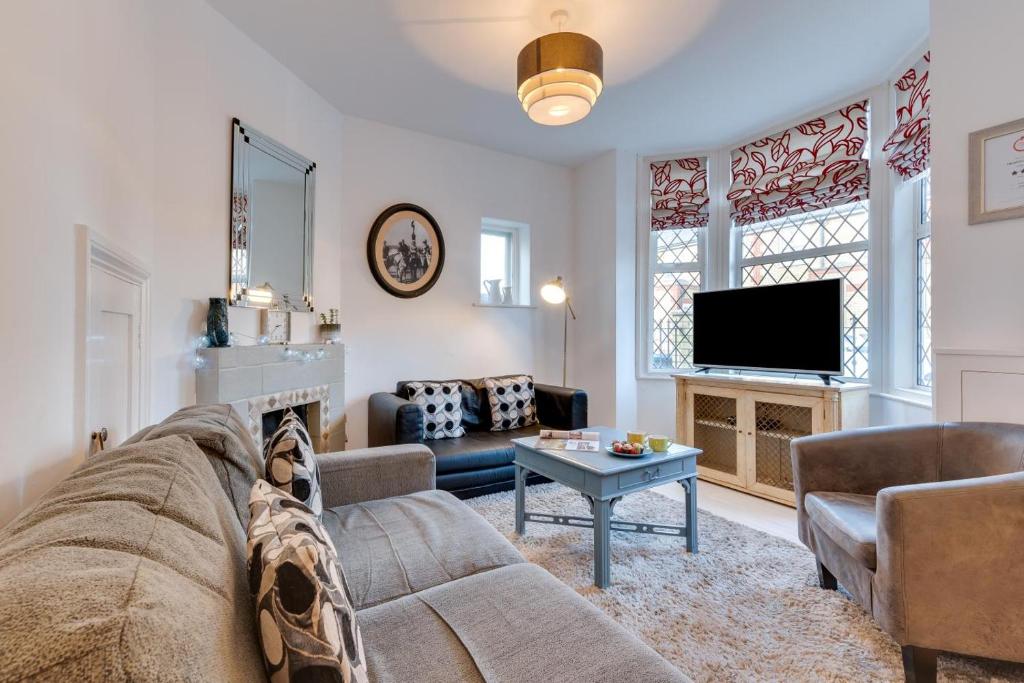 een woonkamer met een bank en een tv bij Millers Cottage in Broadstairs